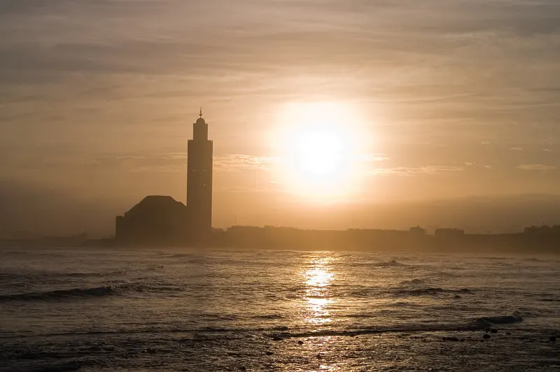 Hassan II Mosque silhouetted against the Atlantic sunset in Casablanca